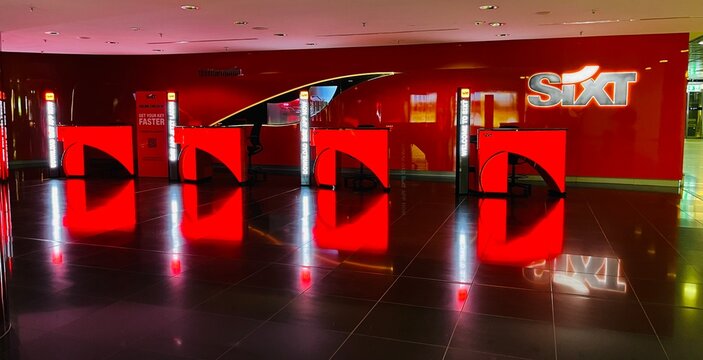 Germany, Hanover, August 25, 2026: A modern Sixt car rental counter featuring the company logo and a red wall
