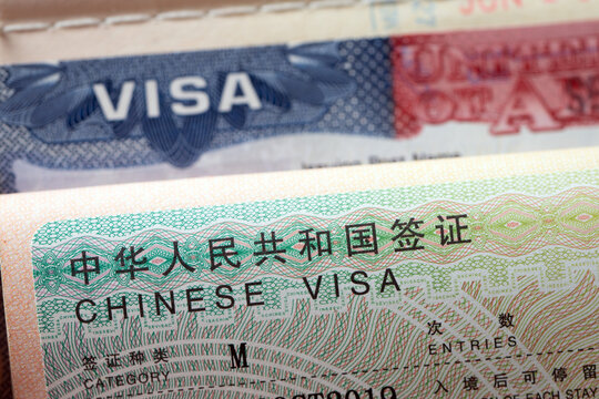 Both a China visa and a United States visa inside open passport pages. Ideal image for international relations, global travel, diplomatic affairs, trade, travel permits, and immigration topics.