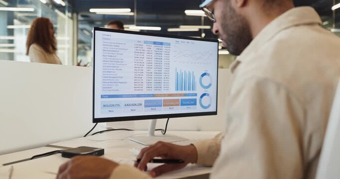 Businessman analyst manager reviewing finance analytics charts. He reviews a computer spreadsheet with charts, verifying figures for accurate reporting. Concept: reliable financial data analysis.