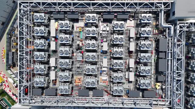 Top down view of the rooftop cooling plant of a west London data centre showing grids of fan units and pipework within a steel service frame