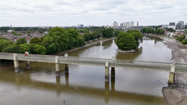 Victorian lattice girder railway bridge crosses the tidal river on cast iron piers at low water