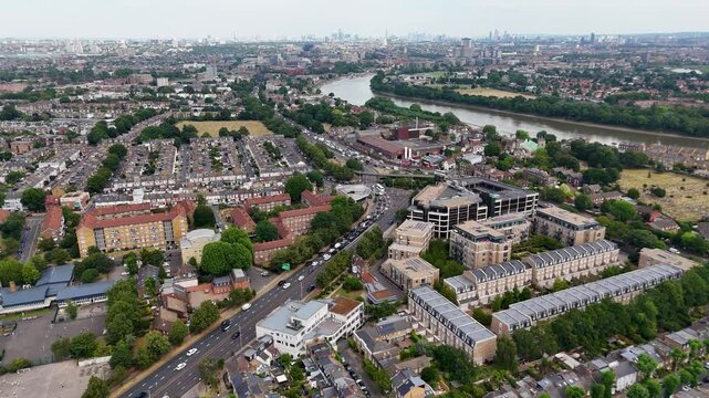 Wide view over a west London suburb with its main road, river bend and the distant towers of the city on the horizon
