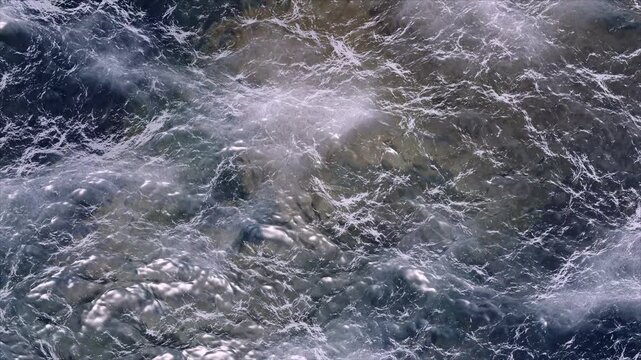 Abstract motion background shows deep blue ocean water with swirling currents and turbulent surface details, creating a dynamic visual flow.