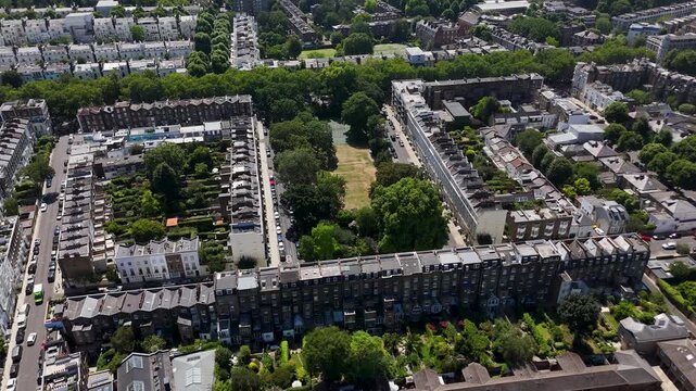 Rows of terraced houses form a rectangle around a private communal garden square of lawn and mature trees