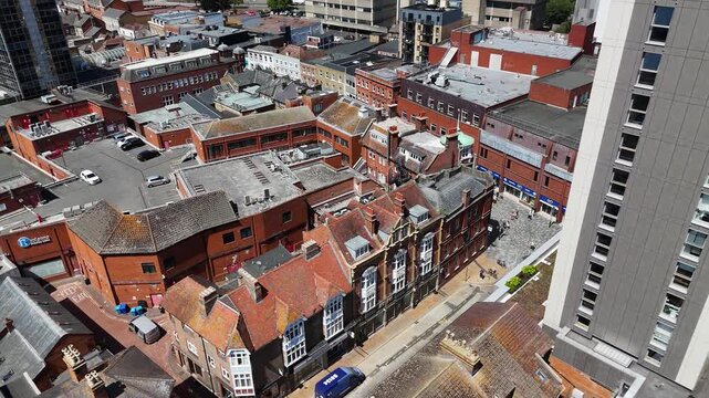 Victorian shopfronts and brick rooftops of an old high street sit beside the sheer cladding of a new residential tower