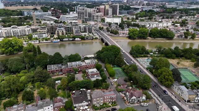Road bridge crosses the river between a leafy suburb and a riverside quarter of apartment blocks and moorings