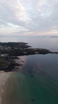 Vertical - Praia de Paxos sandy cove with rocky shore and calm sea in Galicia Spain