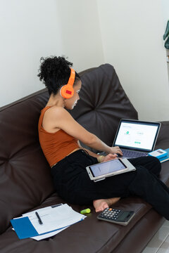 Woman working from home using laptop and headphones