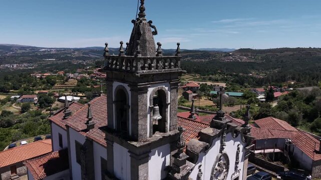 Aerial - Igreja de S&atilde;o Tiago Mondr&otilde;es Vila Real granite bell tower above village rooftops