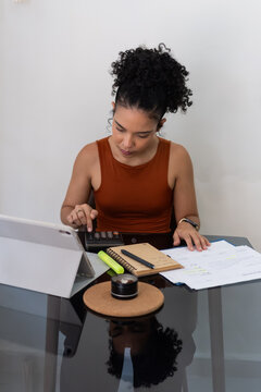 Woman calculating finances while working from home