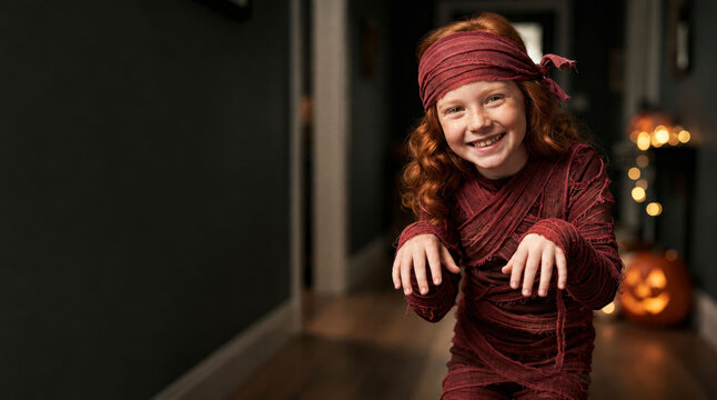 Joyful Red-Haired Girl Wearing Red Mummy Costume for Halloween