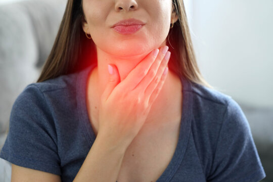 Close Up of Young Woman with Hand on Neck Suffering from Sore Throat and Painful Swallowing
