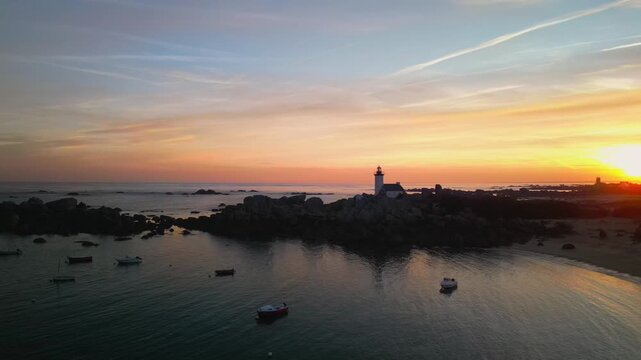 Aerial view sunrise over lighthouse on a rocky coastline. Normandy, France. Travel and nature footage with copy space
