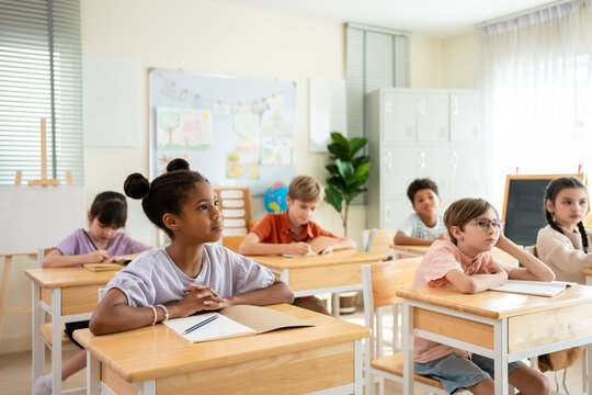 Diverse young girl and boy learning in classroom at elementary school. 