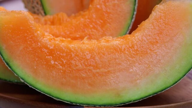 Fresh cantaloupe melon sliced on wooden