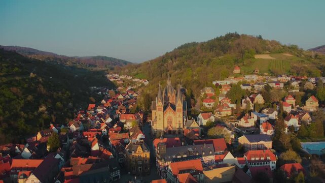 4K Drone Backward Flight Over Heppenheim Cathedral Towers Revealing Cityscape and Hills at Golden Hour