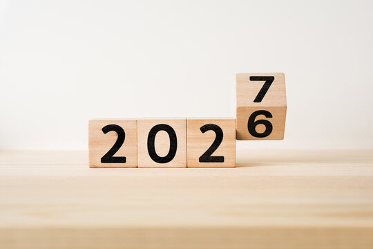 Wooden cube flipping from 2026 to 2027 for new year concept with copy space on white background
