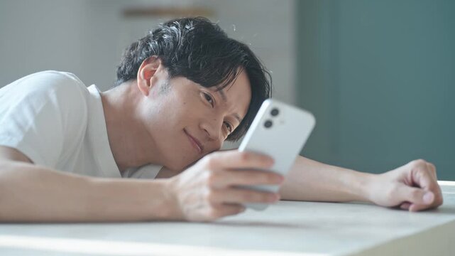 笑顔でスマホを使う男性。アプリ、SNS、動画、ゲーム、リラックス、検索、web、DX、AI、配信
