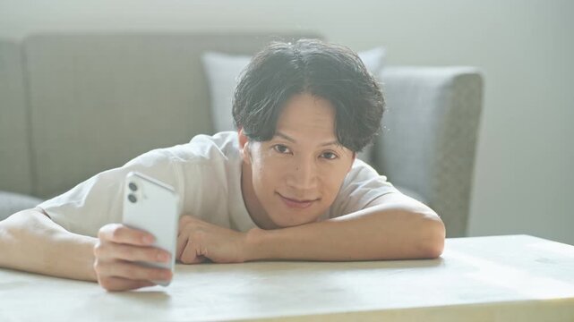 笑顔でスマホを使う男性。アプリ、SNS、動画、ゲーム、リラックス、検索、web、DX、AI、配信