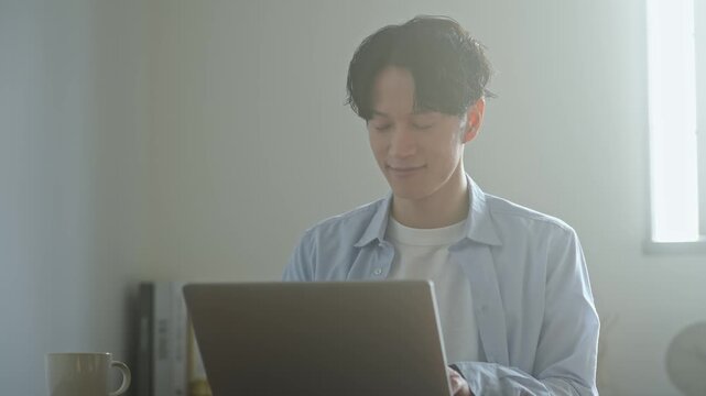 ノートPCを使う男性。パソコン、仕事、作業、テレワーク、副業、資格、カジュアル、DX、IT、ビジネス