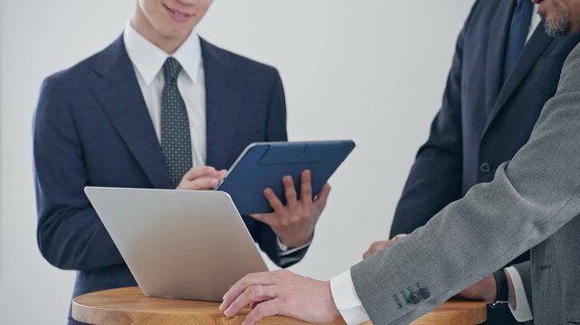 Business professionals conversing while looking at a laptop. Meetings, teamwork, groups, DX, IT, human resources, company.