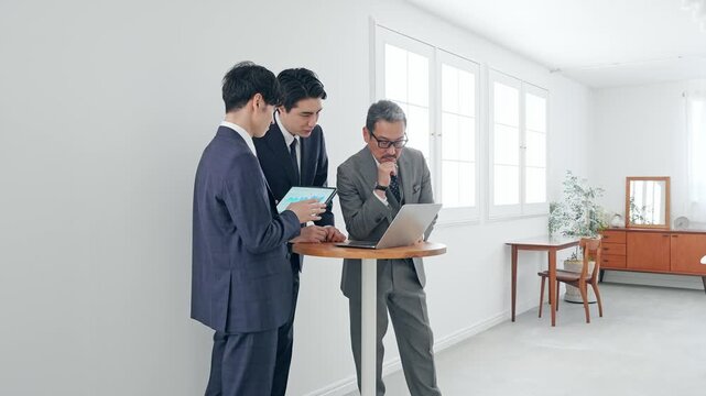ノートPCを見ながら会話するビジネスパーソン。会議、チームワーク、グループ、ミーティング、人材、会社