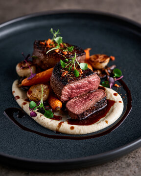 Exquisite fine dining venison loin with red wine reduction, root vegetable pur&eacute;e and elegant gourmet presentation.