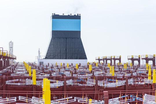 Lashing bridge and aft deck of a newly built container ship, featuring new container securing equipment, lashing fittings and a prominent exhaust funnel at the stern.