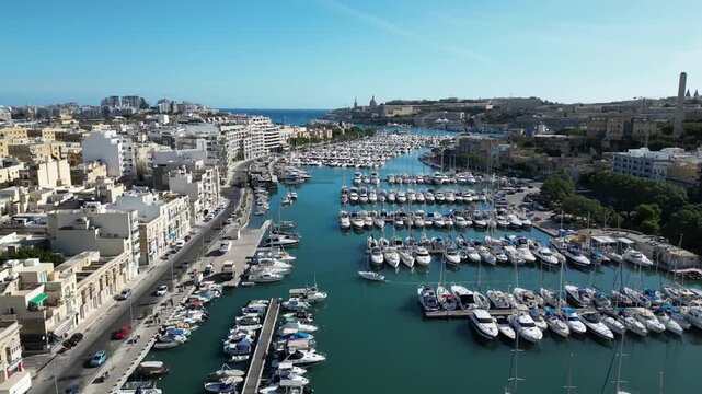 Cinematic drone footage showcasing the boats, waterfront, and urban landscape of Msida Harbor