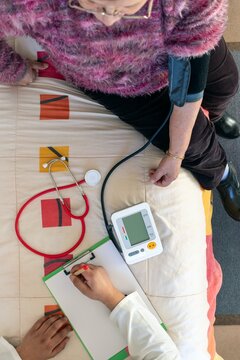 Senior woman receiving a home blood pressure check