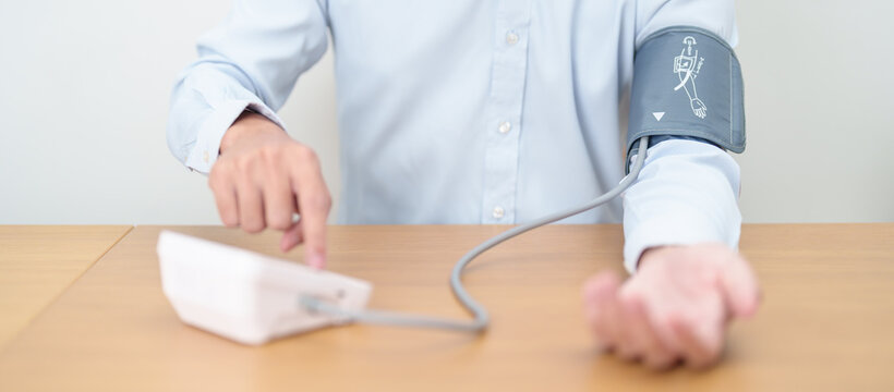 Man checking Blood pressure by Blood pressure monitor with Cuff. Systolic, SYS, Diastolic, DIA, Pulse, Hypertension, Hypotension, Heart rate, Cardiovascular Disease and May World hypertension day