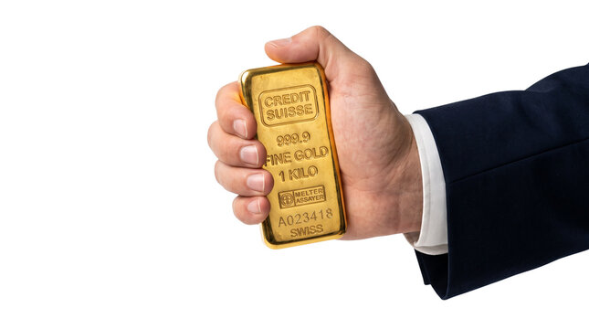 Businessman in a suit holding a heavy one kilogram fine gold bar isolated on transparent background representing wealth and financial success