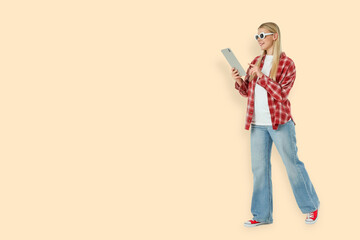 Young woman interacts with tablet and smiles in casual outfit © Atlas