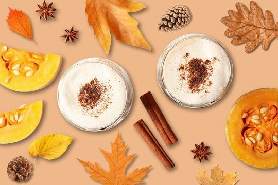 Autumn. Two glasses of pumpkin spice drinks surrounded by vibrant autumn leaves