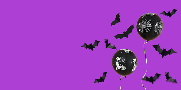 Halloween. Balloons featuring spooky designs float against vibrant purple background