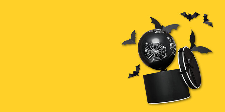 Halloween. Black Halloween decoration with spider web and bats on bright yellow backdrop