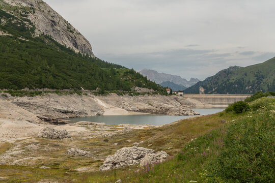 Canazei, Italy. Lago di Fedaia reservoir with exposed shoreline and low water level caused by drought in the Dolomites