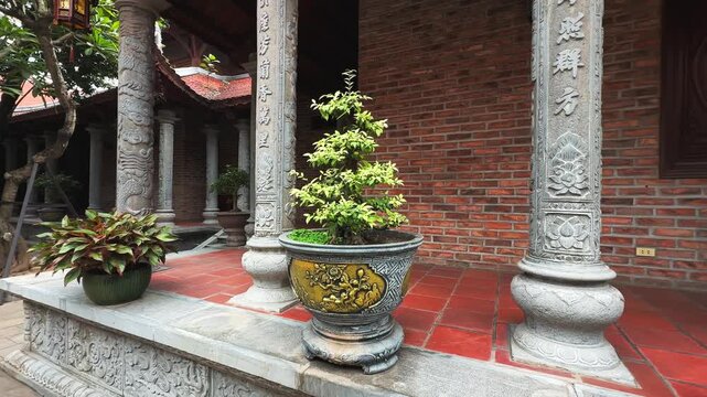 Bonsai Trees and Inscribed Stone Columns at Hong Phuc Tu Hoe Nhai Pagoda. Orbit cinematic motion