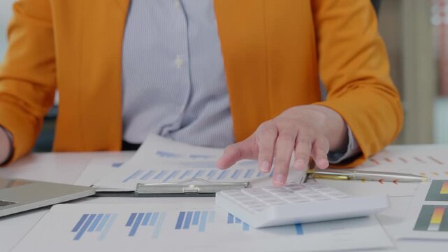 Businesswoman calculating financial data using a calculator