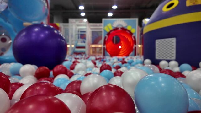 Colorful plastic balls in a vibrant children's indoor playground ball pit.
