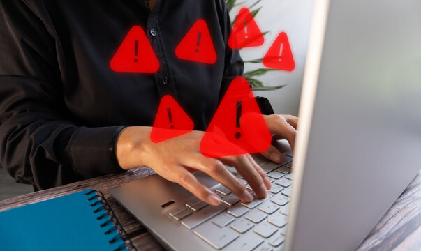 Red warning symbols float above typing hands