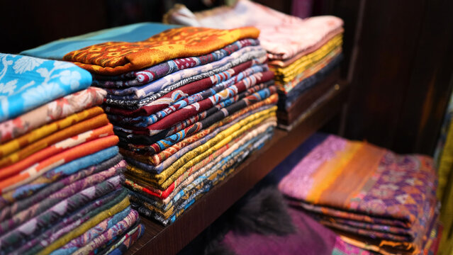 Stacks of Colorful Traditional Arabic Fabrics on Display Shelves