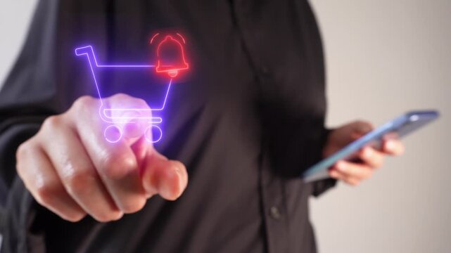 A businesswoman holding a smartphone while pointing forward at a virtual shopping cart icon with a notification bell