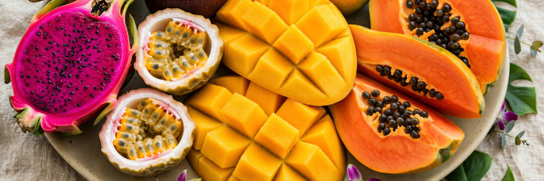 Vibrant collection exotic tropical fruits dragonfruit passionfruit mango papaya slices plate banner