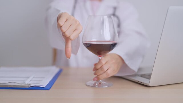 Doctor hand show thumb down to Wine, quitting drink for healthy liver, prevent Alcoholic cirrhosis and cancer, World No Alcohol Day, medical advice for sobriety and Alcoholism and addiction concept