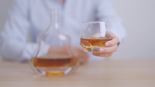 man with glass of cognac on table, suffering from alcohol addiction and alcoholism concept. depicting emotional distress, depression, substance abuse problem, unhealthy lifestyle and mental health
