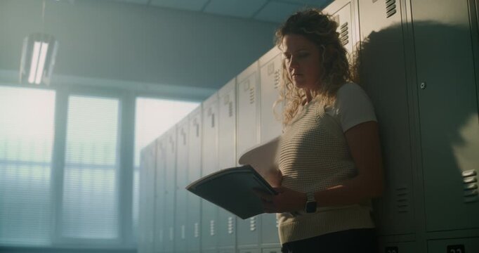 Experienced Teacher Leans Against Lockers in Corridor, Embracing Short Restorative Break Away From Classroom Noise. Compassion Fatigue, Self Care, Educator Wellness, Everyday Life in Modern Schools.