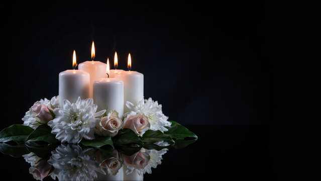Memorial white candles with flowers on black background, funeral sympathy arrangement, mourning ritual candles with roses