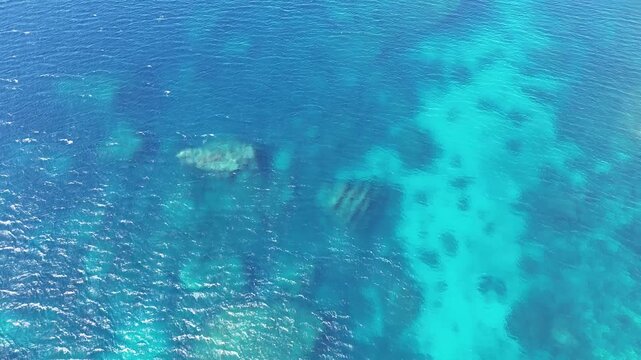 reef shallow turquoise water submerged limestone rock formations seabed texture pattern malta mediterranean sea aerial drone footage marine coastal natural landmark overhead view