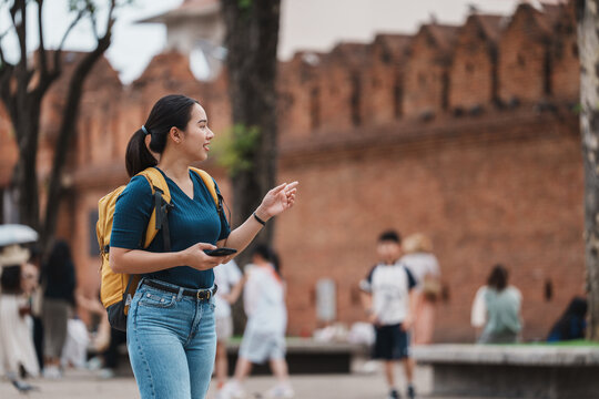 Asian woman tourist backpacking discovering ancient city wall